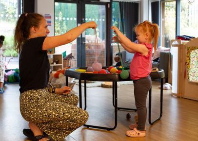 Educator playing with felt balls with a small childq